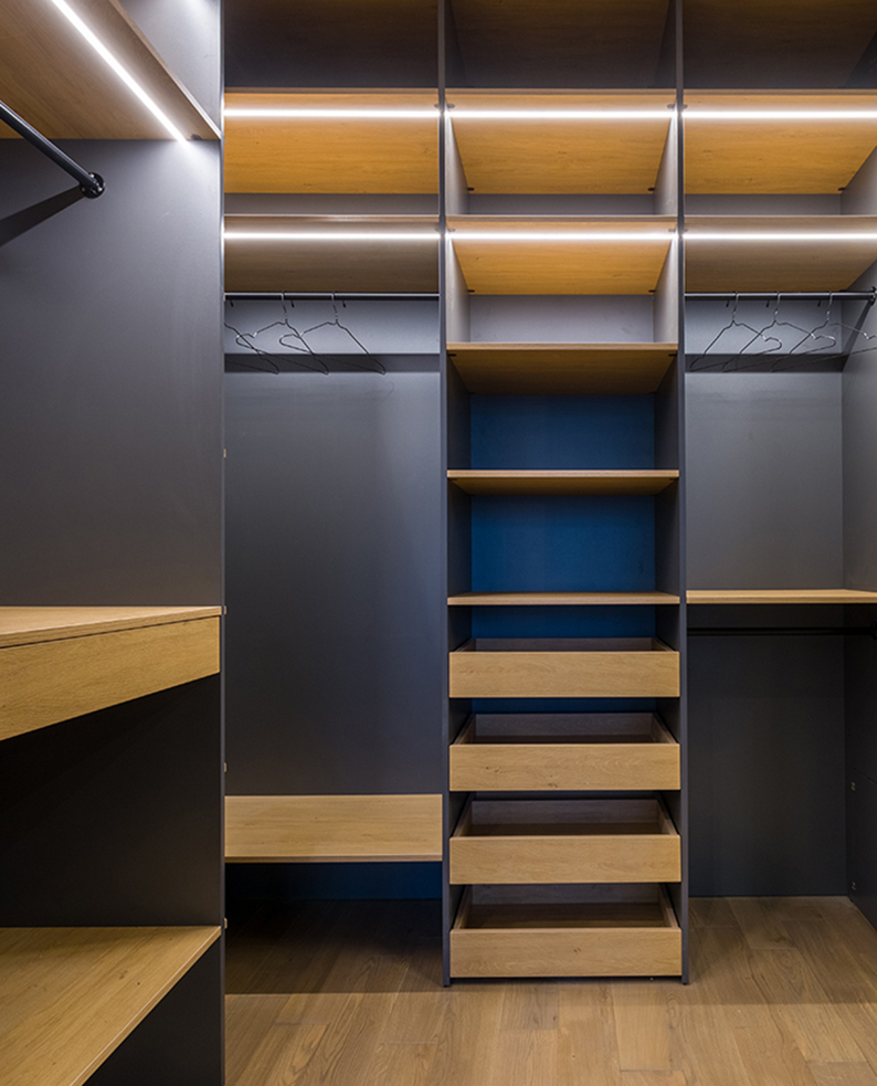Cabina armadio con mensole in legno e illuminata dai profili a LED LEDRE.