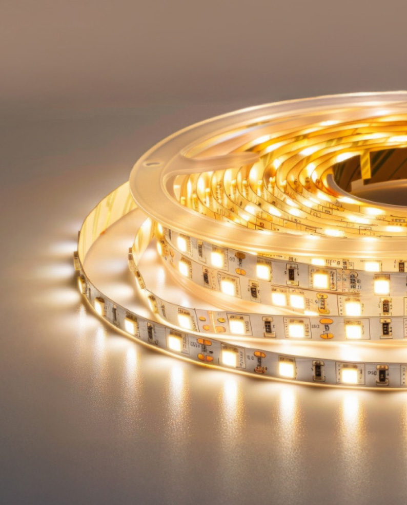 Strip LED flessibile con circuiti stampati, illuminata e su sfondo bianco.