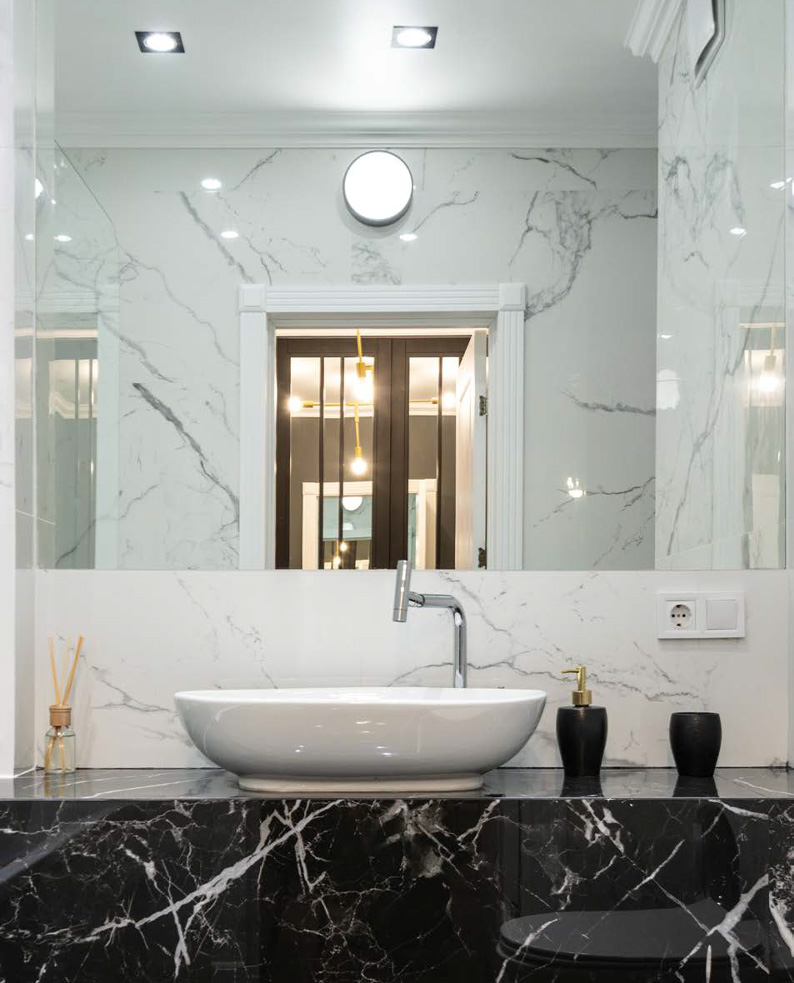 Bagno elegante e raffinato illuminato dall'apparecchio a LED SORELI fissato a parete sopra la porta.